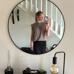 Beige ärmlös topp med axelvaddar - Säljer en beige ärmlös topp med markerade axlar och rund halsringning. Toppen har en loose fit och är tillverkad i mjuk bomull, perfekt för en chill och trendig look. Enkel att styla med både jeans och kjol.