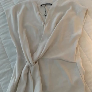 Zara omlott blus vit - Säljer min fina Zara blus i storlek xs! Säljer pga att den är för stor för mig. Jag använder en säkerhetsnål vid överdelen men det behövs inte för alla, kan skicka med säkerhetsnål ifall det skulle behövas! Skriv för fler bilder eller tankar!! 💞