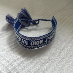 Blått armband från Dior med tofsar - Säljer ett snyggt dior armband, armbandet är helt nytt och är aldrig använt. Storleken går att justera. Kontakta mig vid frågor!🤝