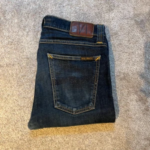 Mörkblå nudie jeans - Snygga mörkblå nudie jeans i ny skick. De är endast använda ett fåtal gånger och mycket bra skick. Storlekn på jeansen är W31/L32