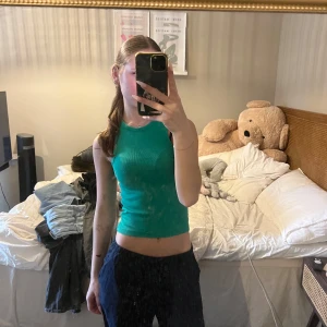 Grön ribbad linnetopp - *färgen är som på bild 3! Säljer en grön ribbad linnetopp med tight passform och rund halsringning. Toppen är ärmlös och croppad, perfekt för varma dagar eller att styla med lager på lager. Enkel och stilren design som är lätt att matcha med olika outfits.