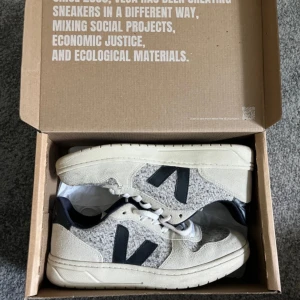 Veja sneakers i beige och grå ull - Snygga Veja sneakers med beige mockadetaljer, gråmelerad ull och svarta V-loggor på sidorna. Köpta på NK men är tyvärr för små för mig nu☺️