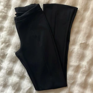 Svarta bootcut byxor - Snygga svarta byxor med bootcut-snitt. De har en klassisk look med utsvängda ben och passar perfekt till sneakers eller boots. Byxorna är stilrena och enkla att matcha med olika outfits. Från Nelly.