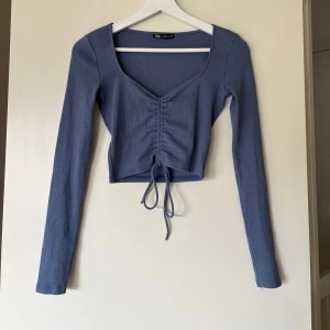 Blå topp med snörning från  Zara stl S  - Topp från Zara med långa ärmar och snygg snörning framtill. Använd några gr 