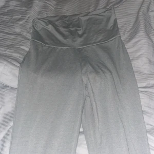 Grå mjukisbyxor från H&M - Grå mjukisbyxor från H&M med hög midja och bred linning. Byxorna är i mjukt och stretchigt material, perfekta för chill dagar eller när du vill vara extra bekväm. Snygg enkel design utan synliga detaljer eller mönster.