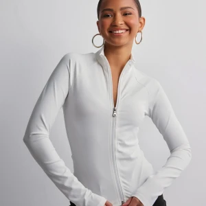 Zip-up träningströja  - Vit zip-up träningströja från Nelly! Används fåtals gånger.