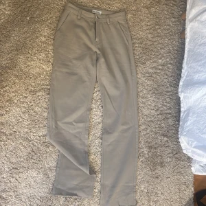 Beige chinos från Skogen XS - Snygga beige chinos från Skogen i storlek XS. Klassisk rak passform med fickor i sidorna och hällor för bälte. Perfekta för en clean och stilren look. Aldrig använda 