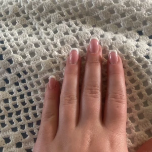 Fransk manikyr med vita tippar - Snygga naglar med klassisk fransk manikyr. Basen är ljusrosa och tipparna är målade i vitt för en fräsch och stilren look. Perfekt för dig som gillar naturliga men ändå fixade naglar.