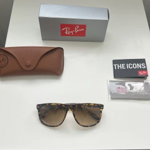 Ray-Ban Wayfarer leopardmönstrade solglasögon - Snygga Ray-Ban Wayfarer solglasögon med leopardmönstrad båge i brunt och gult. Glasen är bruna med snygg toning. Kommer med originalfodral, putsduk och box. Perfekta för dig som vill sticka ut med en klassisk men trendig look.