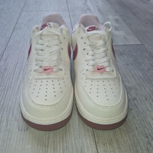 Nike Air Force 1 Low ‘Valentine’s Day 2023’ - 🩷 Nike Air Force 1 Low “Valentine’s Day 2023” – Strl 38  Unika Nike Air Force 1 sneakers i vitt skinn med vinröda detaljer och körsbärsbroderi av två hjärtan på sidan. Perforerad tå, klassisk rund tå och en snygg kontrast mellan ljus ovandel och vinröd sula. Limited edition från Alla hjärtans dag 2023.  ✅ Testade inomhus 1 gång – i princip nya. Inga veck, inga skador. 📦 Skickas med spårbar frakt via Plicks trygghetstjänst. 💸 Pris: 1 200 kr  Skriv vid frågor eller för fler bilder! 🌸