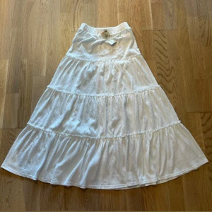 Vit långkjol från Reserved i bomull - Superfin vit långkjol från Reserved med volanger i flera lager. Kjolen har en mjuk resår i midjan och är gjord i ett lätt bomullstyg som känns luftigt och skönt. Perfekt för en somrig look, endast provad! Köpt för 350:-