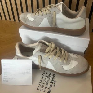 Maison margiela vit/grå st 44  - Ett par maison margiela skor i storlek 44 men passar 43 bättre. Skick är 8/10 bara att de är lite smutsiga | skickas med dustbag och lådan. Skriv vid någon fundering✅