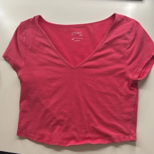 Rosa croppad topp med v-ringning - En enkel och snygg rosa croppad topp från EST.PAC med v-ringad hals och korta ärmar. Perfekt för dig som gillar en basic men ändå trendig stil. Tillverkad i mjuk bomull som känns skön mot huden.