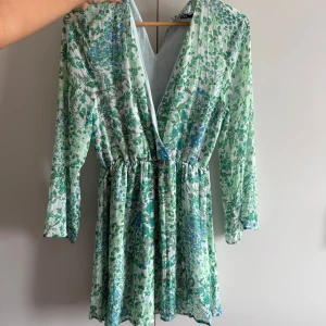 Grönblommig kortklänning med v-ringning - Superfin kortklänning med inbygga shorts. Jätte fint skick💞💞