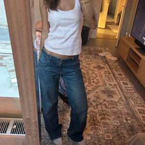 Blå jeans från Lee - Säljer mina super fina blå jeans från Lee som tyvärr blivit för stora på mig:(. De har en normal passform och är lågmidjade med en rak stil. Perfekta för en avslappnad look. Jeansens baksida har två fickor med Lee-logotypen på en läderlapp.