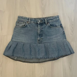 Jeanskjol med volangkant - Supersöt ljusblå jeanskjol med volangkant nertill och klassiska fickor fram och bak. Omsydd från ett par jeans från Monki, ett pyttelitet hål på sidan som visas i bild 4 men det är inget man tänker på 💞Den var lite tight på mig som brukar bära S men annars jättefin! 