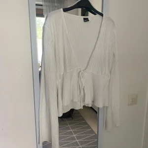 Blus- Gina Tricot - Stilren blus från Gina Tricot- nyskick, endast använd en gång. Säljes pga fel storlek. Fin knytdetalj framtill och unikt mönster på tyget. Storlek XL.