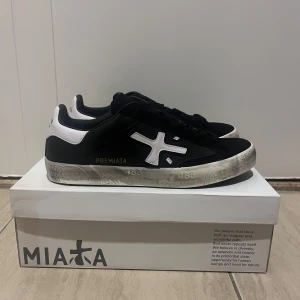 Premiata skor  - Stilrena sneakers från Premiata i svart och vitt med tydlig logga på sidan och hälen. Skorna har snörning, platt sula med unika detaljer och är tillverkade i skinn och syntet. Perfekta för dig som gillar en clean och modern look. Size 42
