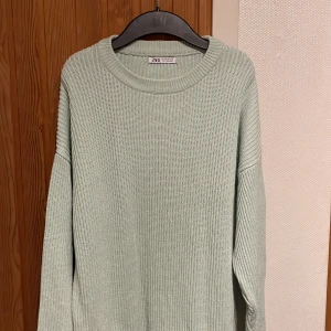 Ljusgrön stickad tröja från Zara - Supermysig ljusgrön stickad tröja från Zara med rund halsringning och långa ärmar. Tröjan har en relaxed fit och ribbad struktur som ger en chill vibe. Perfekt att slänga på sig när det är lite kyligt ute.