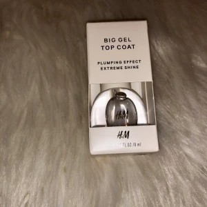Big Gel Top Coat från H&M - Big Gel Top Coat från H&M ger plumping-effekt och extrem glans till dina naglar. Kommer i en genomskinlig formula och snygg, rundad glasflaska med svart text. Perfekt för att få salongskänsla hemma och extra glans på nagellacket.