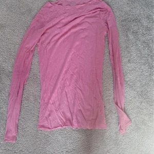 Ljusrosa långärmad topp - Säljer en tunn och mjuk ljusrosa långärmad topp med enkel design. Toppen har rund hals och är figurnära i passformen, perfekt att styla med jeans eller kjol. Materialet känns lätt och skönt mot huden. Har ingen bild med den på!