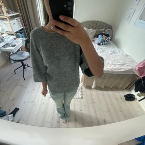 Grå stickad tröja från 157, S - Mysig grå stickad tröja från 157 med rund hals och trekvartsärmar. Jag säljer tröjan för att den inte kommer till användning.