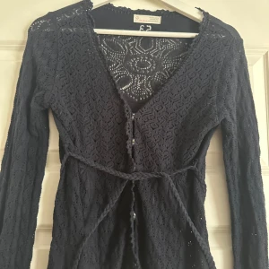 Marinblå Odd Molly kofta  - marinblå kofta från Odd Molly med långärmade ärmar och v-ringad hals. knytband i midjan, en knap saknas men inget som syns 