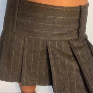 Grå plisserad kortkjol med ränder - Supersnygg kjol i tyg, perfekt nu till hösten💞💞kjolen är storlek 40 men passar bra på mig som vanligtvis har storlek 36/38🥰