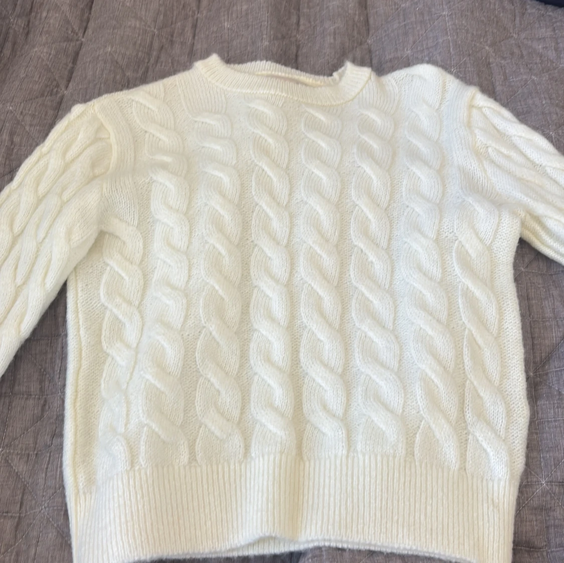 Vit stickad tröja med flätmönster