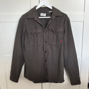 overshirt från R.D.D. - Snygg over shirt från R.D.D i riktigt bra skick. Den är egentligen i den klassiska militärgröna färgen även om ljuset får den att se lite brunaktig ut på bilden.