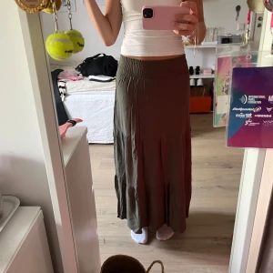 Olivgrön långkjol från  lager 157 XS - Säljer en olivgrön långkjol från lager 157 i storlek XS. Kjolen har en smockad midja som sitter skönt och ser snygg ut. Materialet är mjukt,perfekt för chill dagar. Kjolen har en lätt volang nedtill. Säljer pga att den inte används 💚
