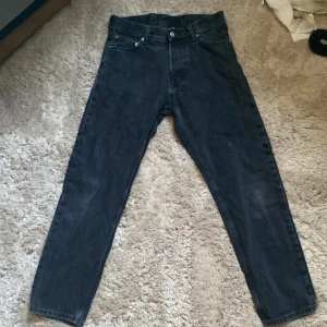Svarta Weekday jeans straight fit - Säljer ett par svarta Weekday  jeans med klassisk straight fit och fem fickor. Jeansen har hög midja och är tillverkade i robust denim. Perfekt för dig som gillar tidlös stil och vill ha ett par jeans som funkar till allt. Passar både tjejer och killar.