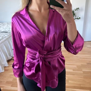 Blus i otrolig färg  - Materialet är mjukt och stretchigt, från Italien. Storleken på denna är runt M, går att ”justera” storlek i och med att man knyter blusen så tight man vill att den ska sitta. Går att knyta på olika sätt! (Visar inre knyt samt knappar på sista två bilderna) Mycket bra skick! Jag fraktar gärna - köparen står för frakten, annars hämtas blusen upp i Tyresö/Globen 💞