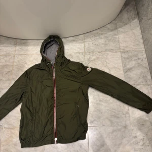 Grön vindjacka från Moncler med huva - Säljer denna otroligt snygga mörkgröna Moncler vindjackan! Denna har knappt används och är i storlek S/36 nypris cirka 9000kr 