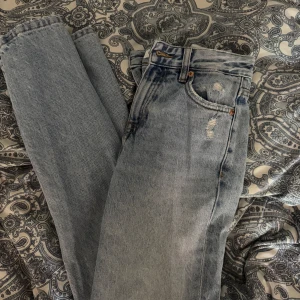 Pull & bear ljusblå jeans  - Ljusblå jeans med hög midja och raka ben. Lite slitningar för en cool vintagekänsla. Snygg passform som sitter tajt över höften och blir rakare nedtill. 