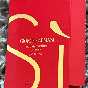 Giorgio Armani Sì Passione Intense EdP - Säljer en provflaska av Giorgio Armani Sì Passione Intense eau de parfum. Doften har noter av svartvinbär, bergamott, jasmin, vanilj och sandelträ. Kommer i en röd och guldig förpackning med en liten sprayflaska inuti. Lite kvar i flaskan 