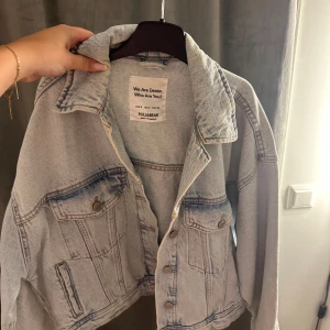 Ljusblå jeansjacka från Pull&Bear - Snygg ljusblå jeansjacka från Pull&Bear i klassisk modell med knappar framtill och två bröstfickor. Knappt använd✨