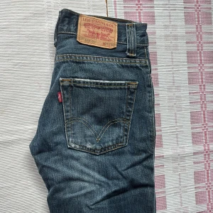 Levi's 511 Slim jeans blå denim - Säljer ett par Levi's 511 Slim jeans i klassisk blå denim med snygga slitningar och. Passformen är slim och raka ben.