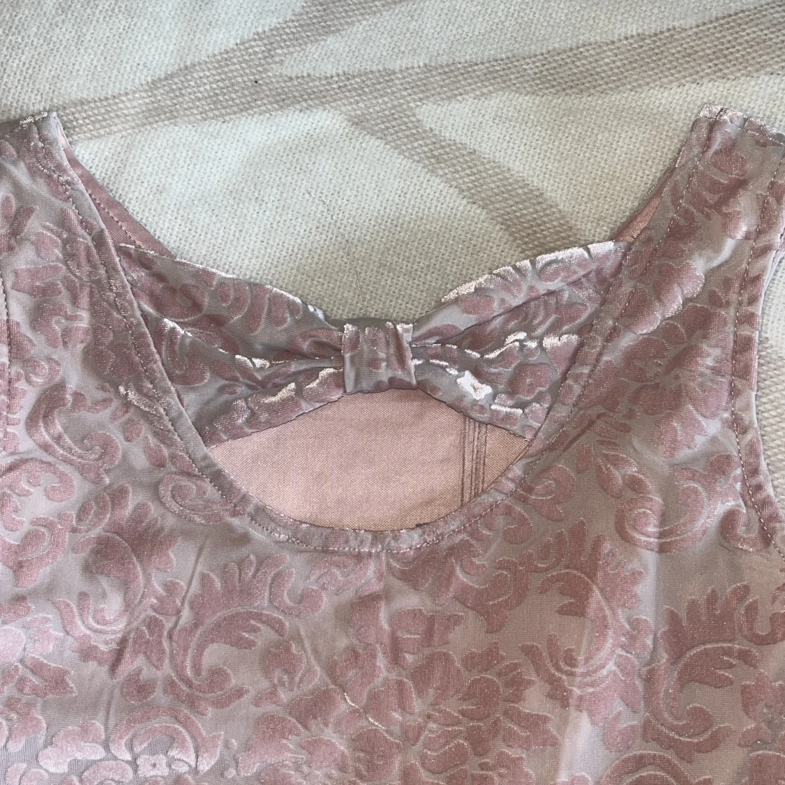 Ljusrosa klänning med rosett och mönster - 1