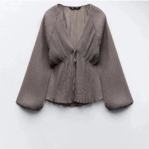 Grå blus från Zara - Elegant grå blus från Zara med långärmad design och knytning framtill. Aldrig använd så nyskick! Storlek s