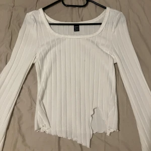 Vit långärmad topp från SHEIN - Vit långärmad topp från SHEIN i storlek S. Endast använd cirka 2 gånger. Nederkanten är vågig och har en split som är en del av modellen. Priset kan diskuteras. Hör gärna av er om ni vill ha mått eller ifall ni har andra frågor 🥰