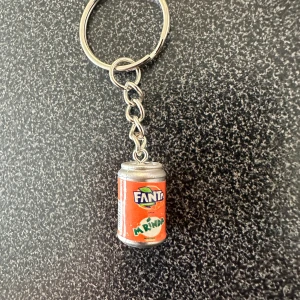 Nyckelring med Fanta/Mirinda burk - Säljer en rolig nyckelring med en miniatyr av en Fanta/Mirinda läskburk i orange och silver. Perfekt accessoar för dig som gillar unika detaljer på dina nycklar eller väska.
