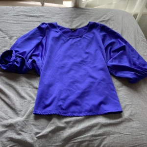 Blå blus med puffärmar - Säljer en blå blus med rund halsringning och stora puffärmar. Blusen har en lös passform och är tillverkad i siden. Perfekt för dig som vill ha något färgstarkt och trendigt. Säljer pga. för stor och köpare står för frakt! 💗