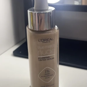 L'Oréal Paris True Match Nude Plumping Tinted Serum 0.5-2 Very Light - Ljus, flytande foundation med serumkänsla från L'Oréal Paris. Innehåller 1% ren hyaluronsyra för återfuktning och ger en naturlig, lätt täckning. Kommer i glasflaska med pipett och har en neutral underton. Helt oanvänd!