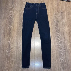 Levi's Mile High Super Skinny jeans mörkblå - Mörkblå Levi's Mile High Super Skinny jeans med klassiska fem fickor, hög midja och smal passform hela vägen ner. Perfekta för dig som gillar en tight och stilren look. Priset går att diskutera, använd några fåtal gånger. Midja 25 och längd 30