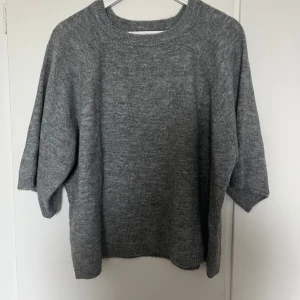 Grå stickad tröja från Lager 157 - Mysig grå stickad tröja från Lager 157 med rund halsringning och trekvartsärmar. Perfekt för lager-på-lager och enkel att matcha med olika outfits. Klassisk och stilren design som passar till många tillfällen.