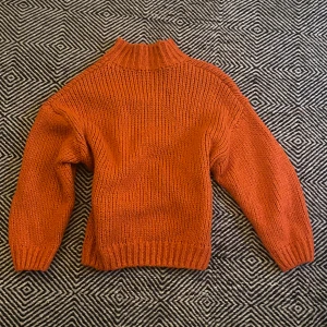 Orange stickad tröja  - Säljer en chunky orange stickad polotröja med lång ärm och ribbade muddar.Passformen är normal och tröjan är mjuk och skön. Använd fåtal gånger men fortfarande mycket fin. (Nypris: 340kr)
