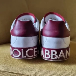 Dolce & Gabbana vita sneakers  - Säljer ett par vita sneakers från Dolce & Gabbana med röda detaljer på häl. 9/10 skick. Riktigt snygga och unika. Pris kan diskuteras!