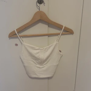 Vit croppad linnetopp från SHEIN - Säljer en enkel och stilren vit croppad linnetopp från SHEIN. Toppen har smala axelband(adjustable )och en rak skärning, perfekt att matcha med jeans eller kjol. Materialet är mjukt och bekvämt. 