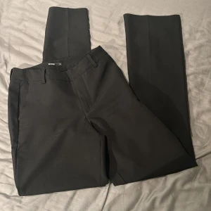 Svarta högmidjade kostymbyxor från BikBok - Snygga svarta högmidjade kostymbyxor från BikBok. Perfekta till en stilren look och enkla att matcha med olika toppar. Materialet känns mjukt och har en lätt stretch.